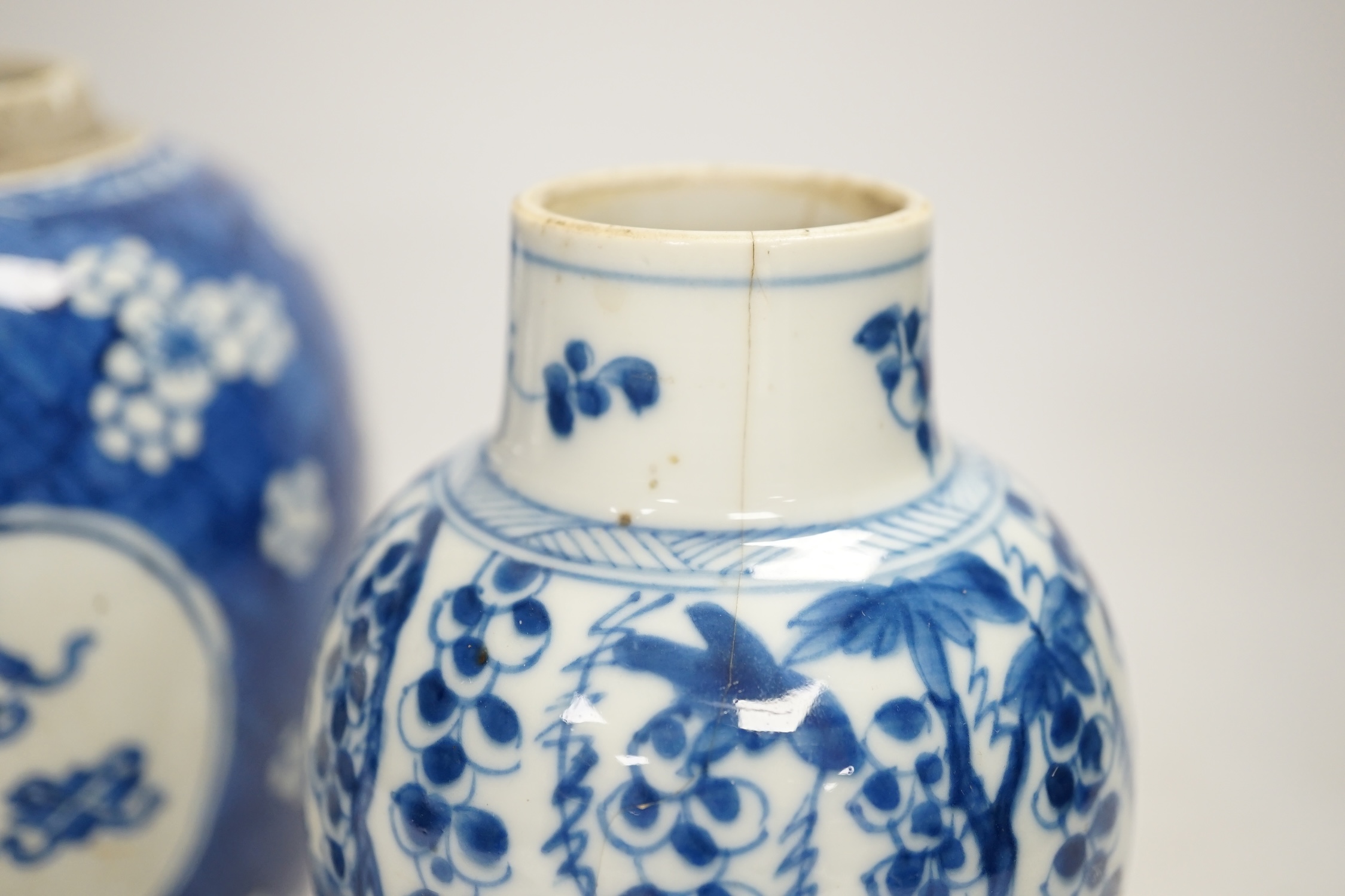 A Chinese Kangxi blue and white jar and a similar vase, jar 19.5cm high. Condition - both cracked and chipped, poor